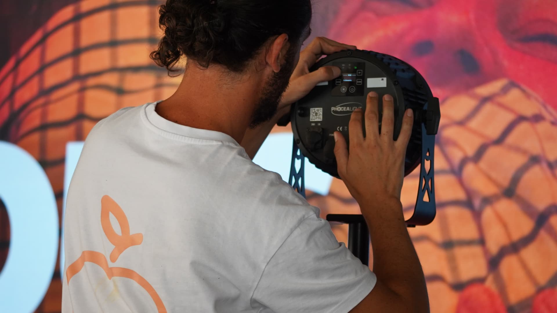 Technicien réglant l'adressage DMX à l'arrière d'un projecteur